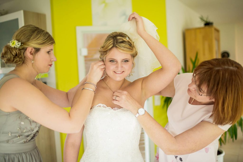 Letzte Handgriffe an der Braut beim getting ready
