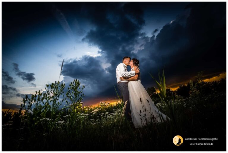 Brautpaar mittleren Alters vor dramatischer Wolkenkulisse